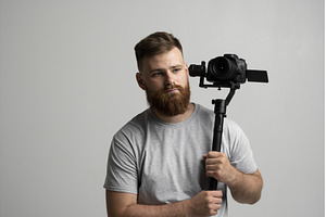 Bearded videographer holding camera, an Industrial Photo by volodymyrshtun13795
