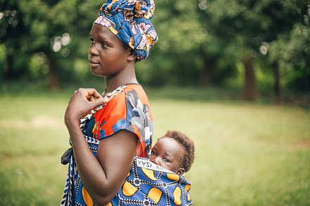 African Mother Carries Child on Back