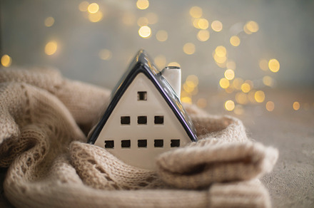 Ceramic house insulated by warm sweater. Concept of protection of house and lac, a Holiday Photo by Anikona