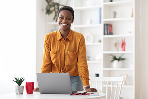 Positive short-haired african american woman posing at office, a Photo by Prostock-Studio
