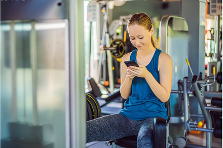 Young woman using phone while, a Sports & Recreation Photo by Elizaveta Galitskaya