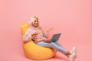 Happy woman making video call on laptop while sitting in beanbag chair, emotion, a Photo by Prostock-Studio (Thumbnail 2 of 2)