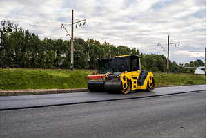 Road roller working on fresh asphalt, an Industrial Photo by volodymyrshtun13795