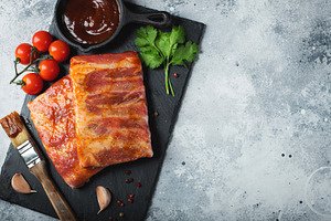 Ready for BBQ raw pork spare ribs with barbecue sauce. Black background. Top vi, a Food & Drink Photo by Budarinphoto
