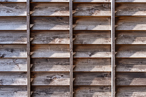 Old wooden fence with shadows and aged texture details, an Architecture Photo by GoodGoods