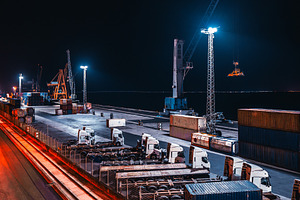 Cargo port with trucks at night, an Industrial Photo by SkyNext