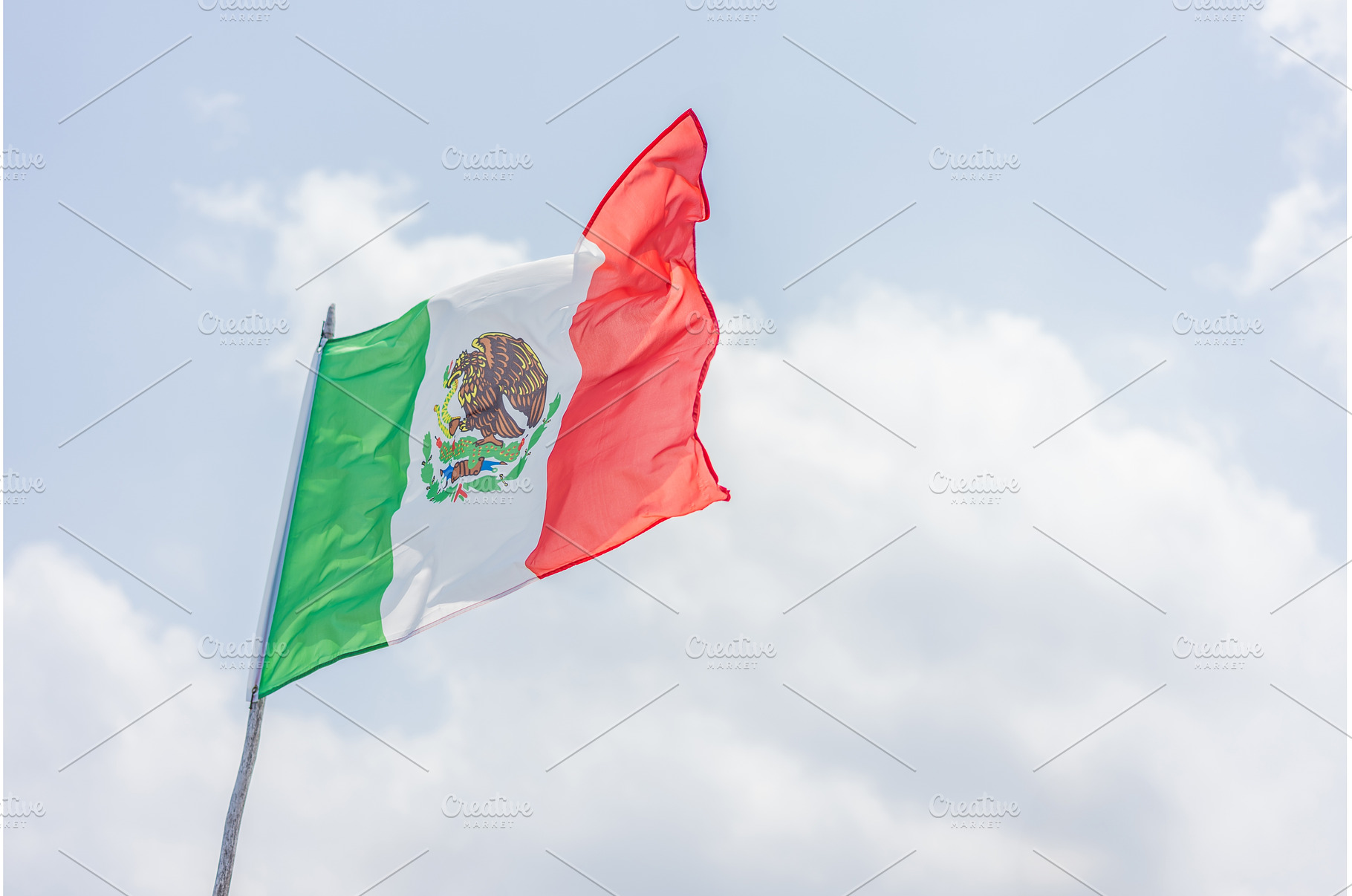 Mexican flag waving against a bright, a Holiday Photo by Elizaveta Galitskaya