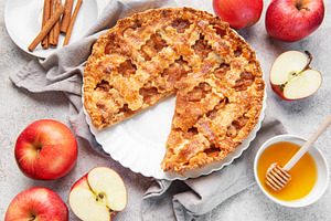 Apple pie with slice removed surrounded by fresh apples, a Food & Drink Photo by Olena Rudo
