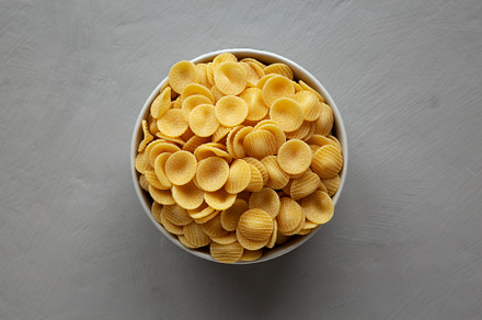 Dry, Uncooked Orecchiette Pasta in a Bowl, top view. Flat lay, o, a Food & Drink Photo by LiudmylaChuhunova
