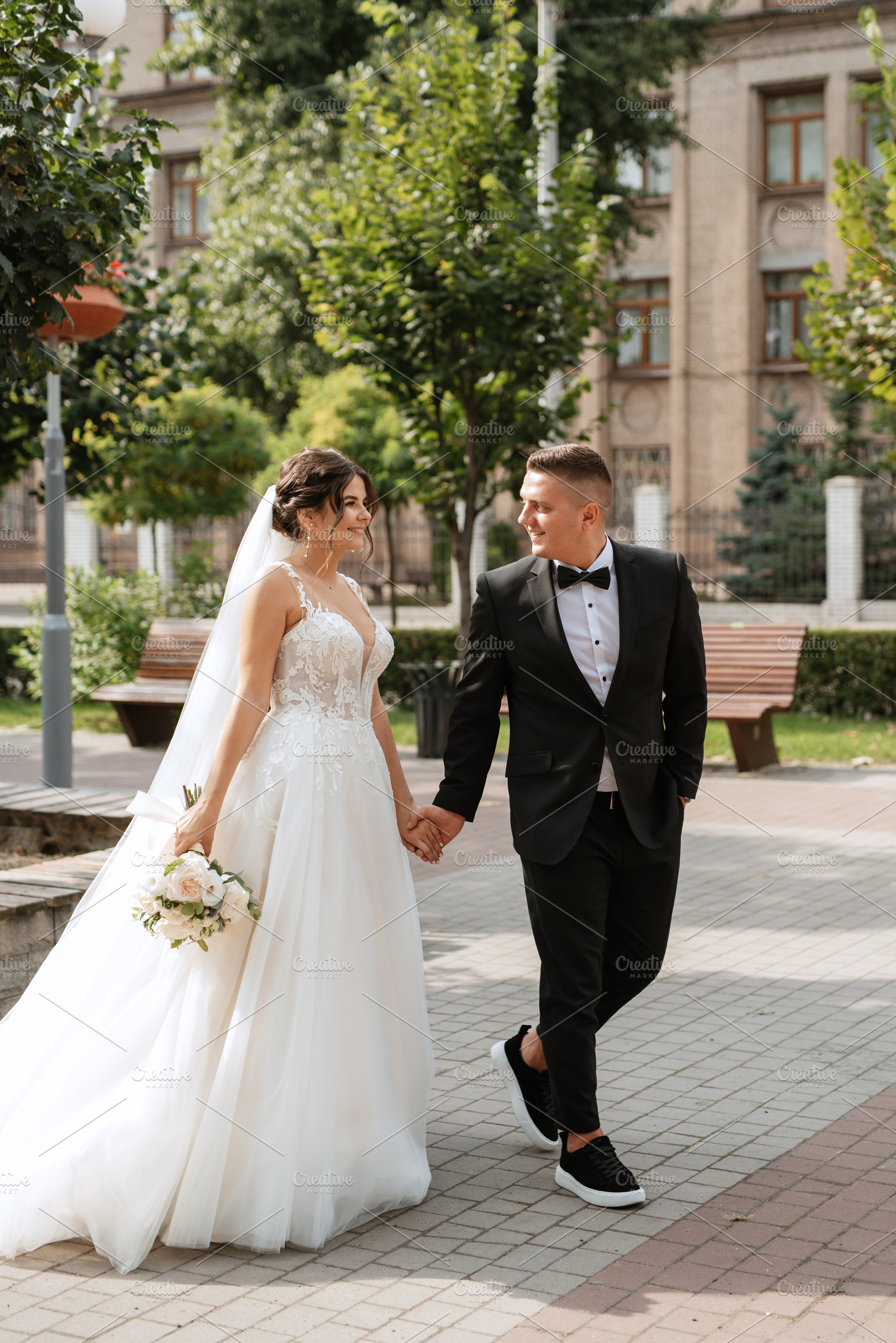 the groom in a brown suit and the bride in a white dress, a Person Photo by Weddings, People, Travel