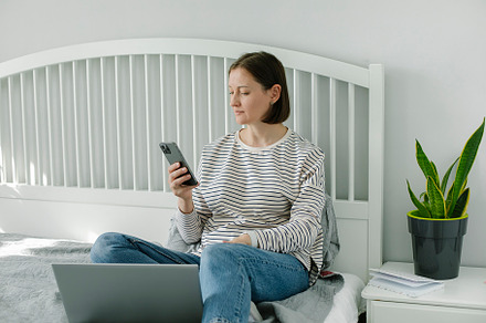 Young woman working from home office. Freelancer using laptop, phone and the In, a Person Photo by Anikona