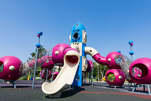 Colorful outdoor playground featuring a rocket-shaped slide, climbing tunnels,, a Sports & Recreation Photo by Ales Munt