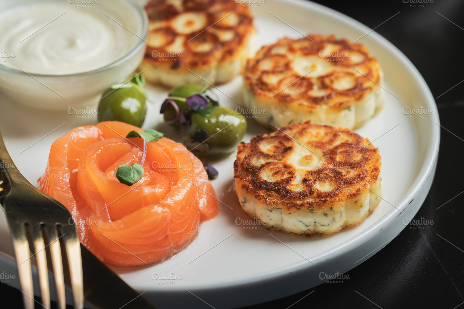 Savory Syrniki with Smoked Salmon, Olives and Sour Cream on White Plate, a Food & Drink Photo by Budarinphoto
