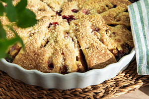 Baked plum dessert with crumb topping on rustic table, a Food & Drink Photo by Olena Rudo