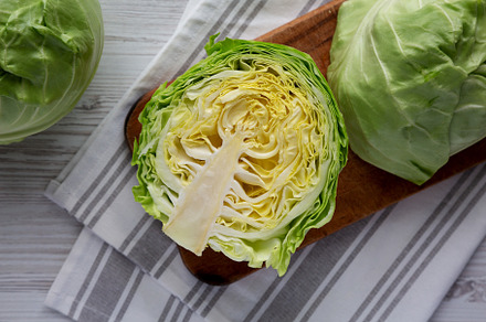 Raw Organic Cabbage on a Rustic Wooden Board, top view. Flat lay, a Food & Drink Photo by LiudmylaChuhunova