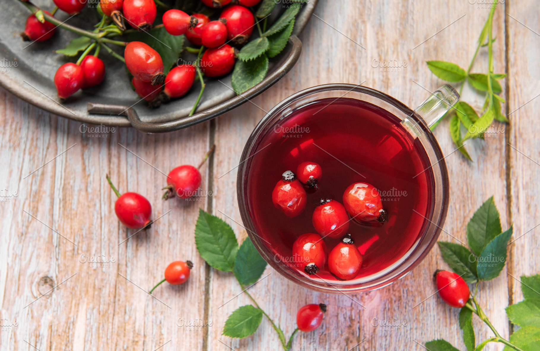 Steaming rosehip tea with fresh rose hips on rustic wooden table, a Food & Drink Photo by Olena Rudo
