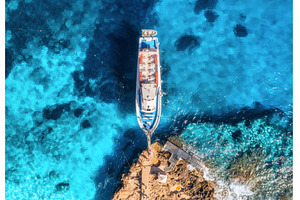 Aerial view of boat and rocky sea