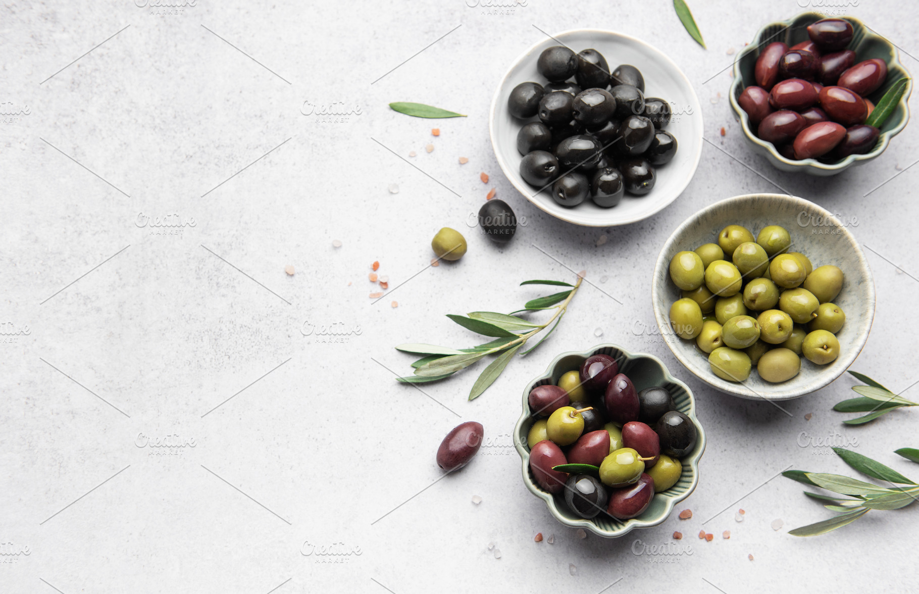 Assorted olives in decorative bowls on white surface, a Food & Drink Photo by Olena Rudo