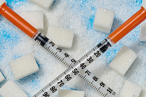 Two insulin syringes crossed over cubes and scattered white suga, a Health & Medical Photo by ndanko