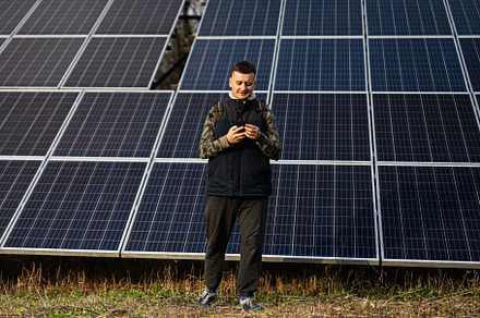 Man with mobile phone on the background of solar panels.  Eco en, a Technology Photo by AS photostudio