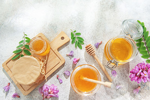Sweet organic honey jars and acacia flowers, a Food & Drink Photo by Olena Rudo
