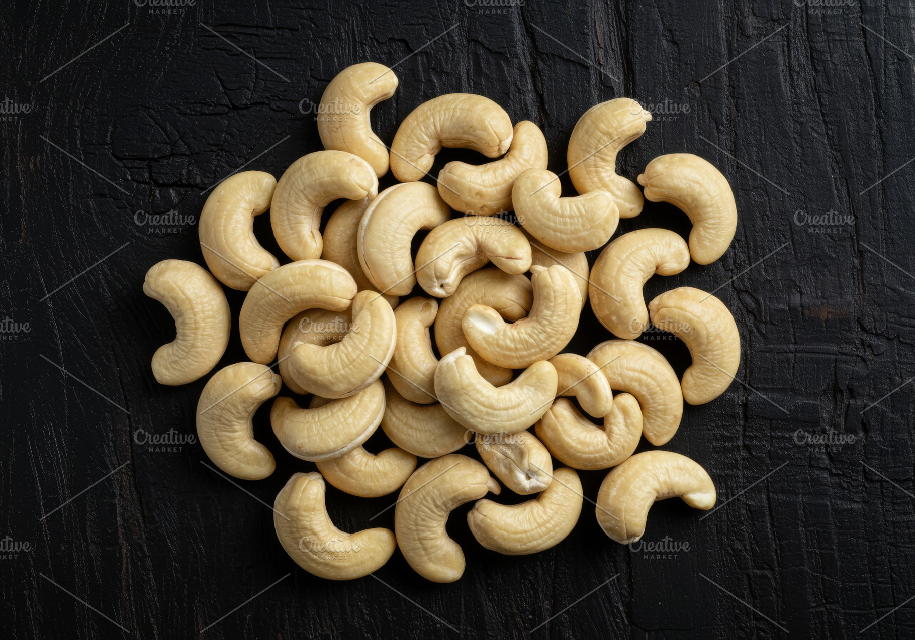 Raw cashew nuts arranged on a dark t, a Food & Drink Photo by professorinc