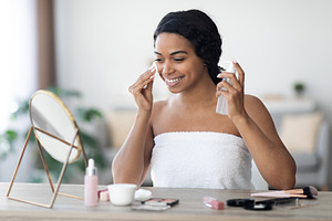 Smiling beautiful african american woman cleansing face