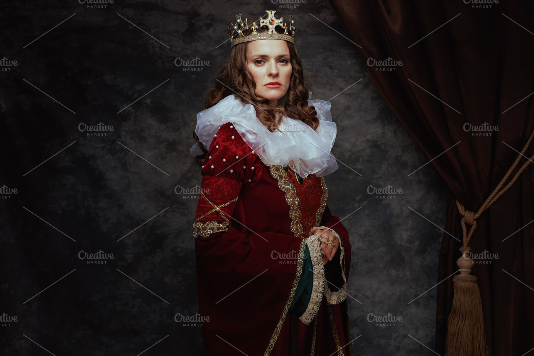 medieval queen in red dress with white collar and crown, a Person Photo by Alliance Images
