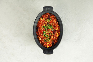 Traditional Mexican chili stew with vegetables in black bowl, a Food & Drink Photo by Natalia Klenova's Shop