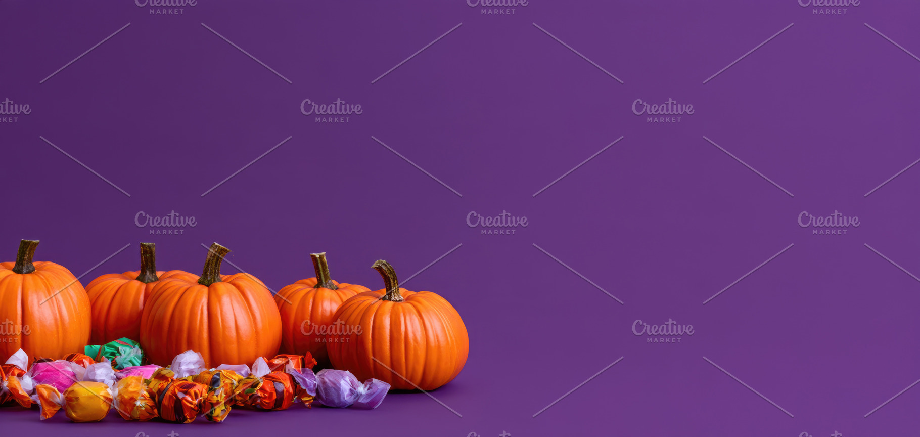 Halloween pumpkins and candy on purple copy space, a Person Photo by José Manuel Gelpi