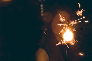 Girl holding sparkler featuring silhouette, black, and dark