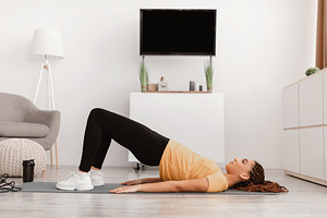 Fitness Woman With Braids Doing Bridge Exercise Training At Home, a Photo by Prostock-Studio
