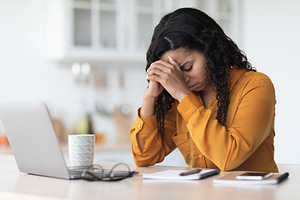 Tired african american lady experiencing burnout, working online