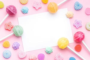 Sweet lollipops and candies and blank greeting card on pink back, a Food & Drink Photo by Olena Rudo
