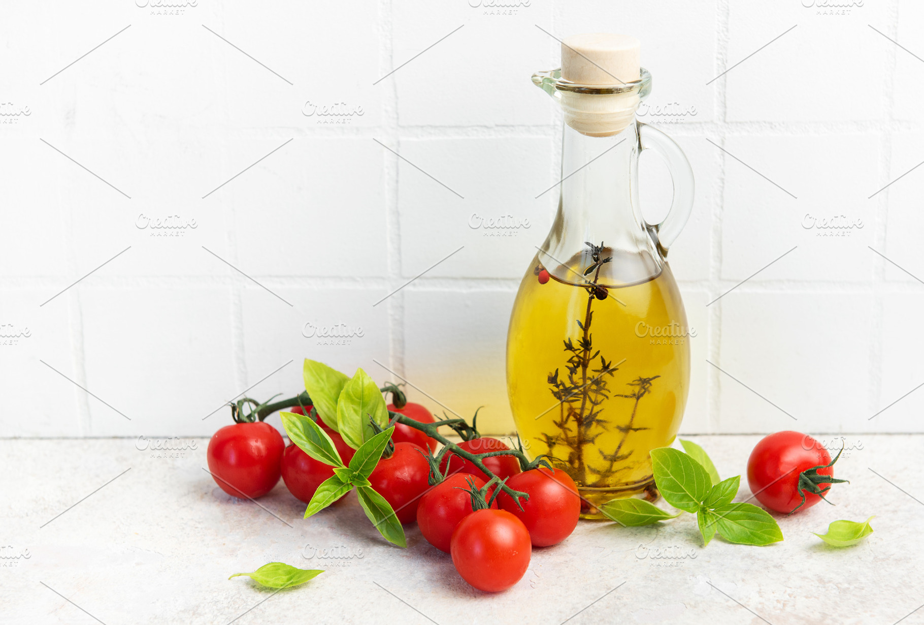 Olive oil bottle with fresh cherry tomatoes basil, a Food & Drink Photo by Olena Rudo