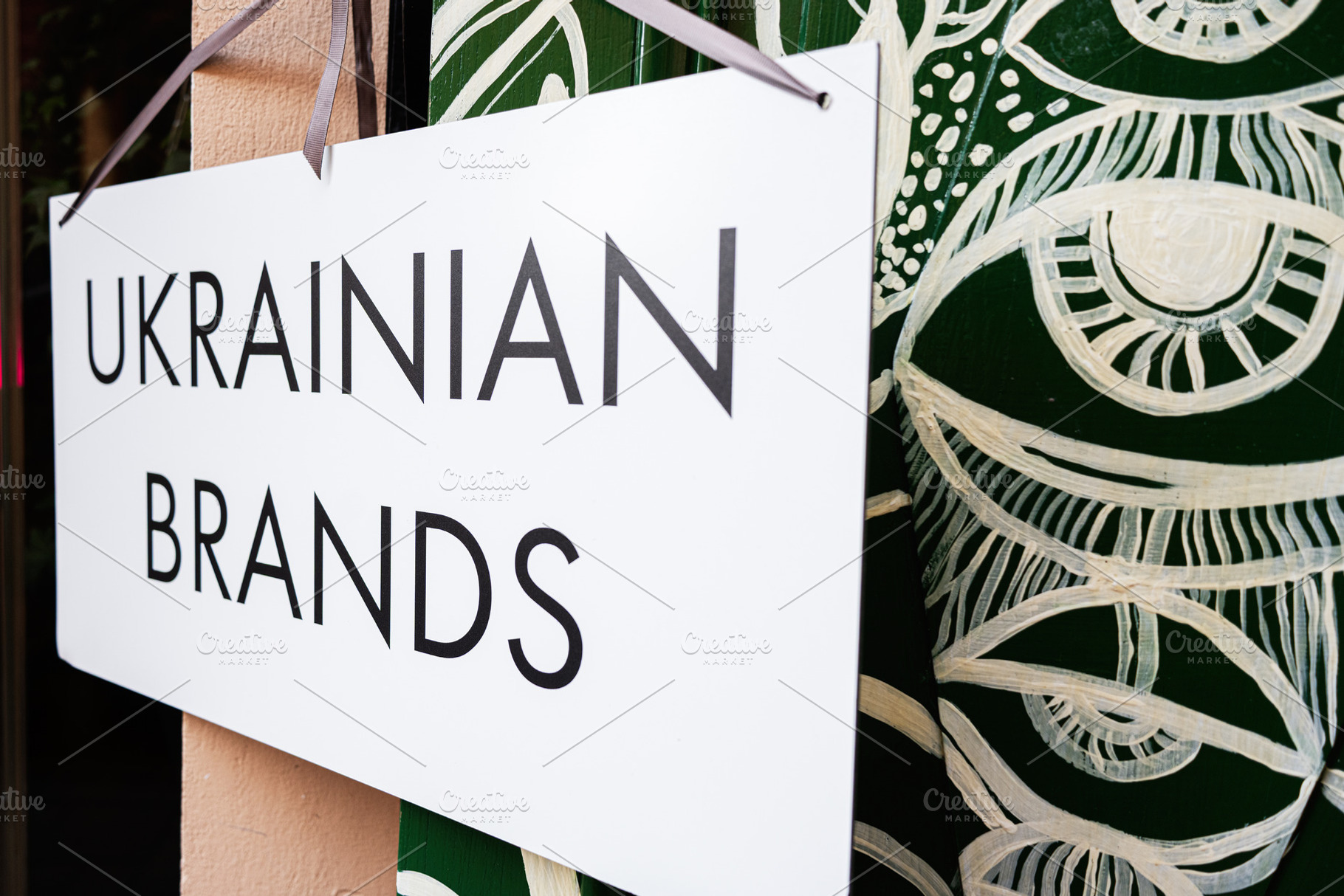 Sign promoting Ukrainian brands with eye catching art in the background, a Photo by AS photostudio
