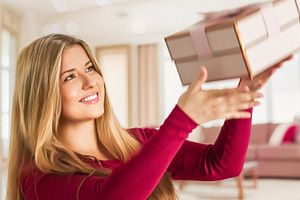 Young woman smiling, looking up while catching a gift box, celeb, a Person Photo by Studio ANNA