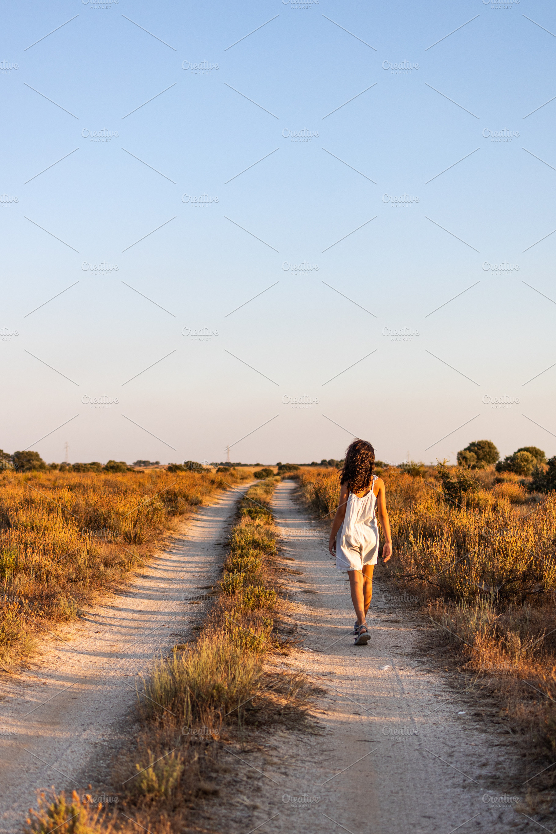 Lonely girl walking on a country road. Back view., a Person Photo by Cosca