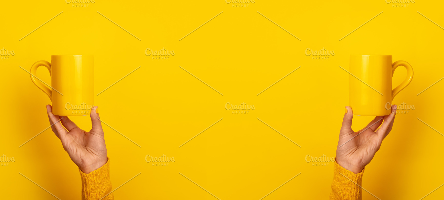 Symmetrical image of two hands in yellow sweaters holding yellow, a Food & Drink Photo by Ales Munt