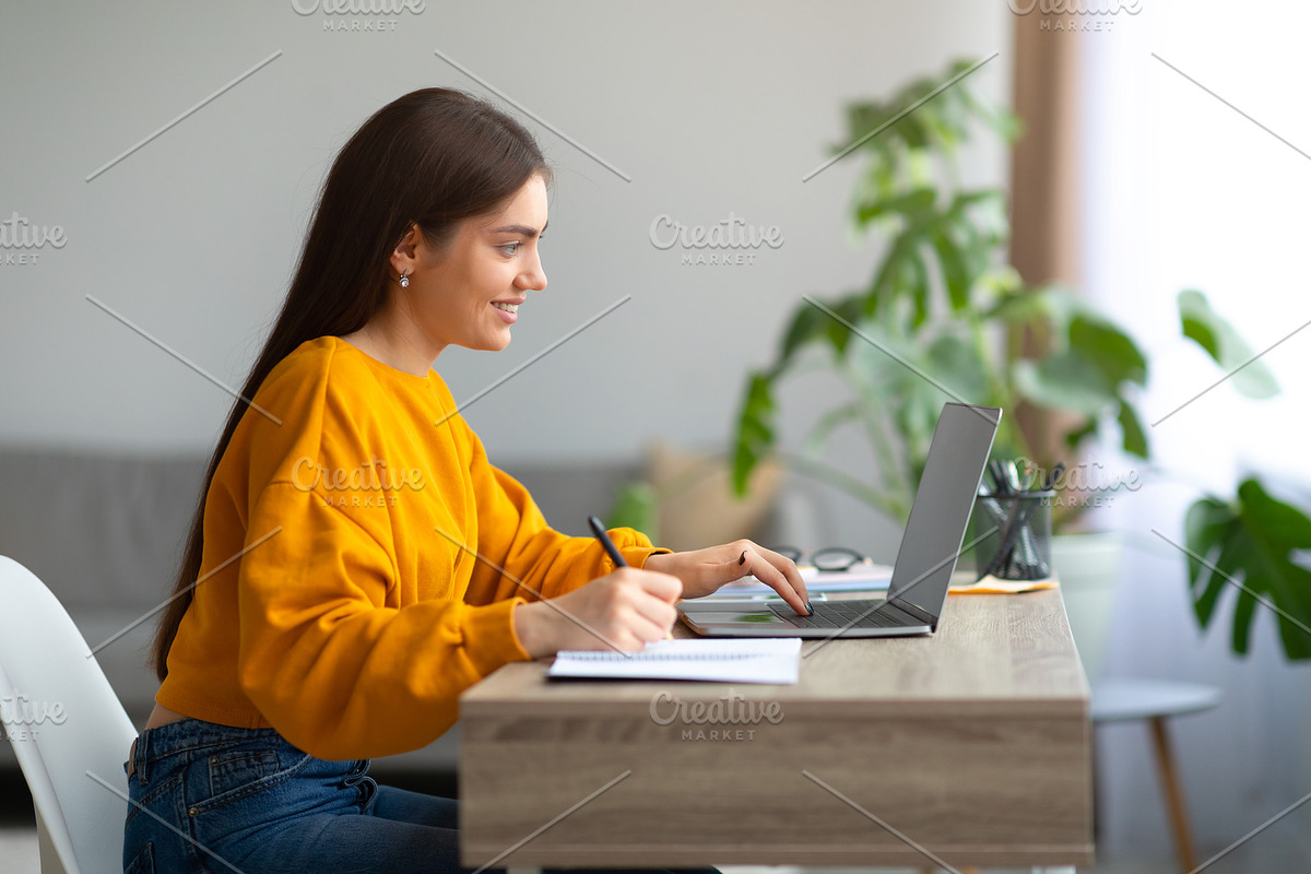 Positive young woman writing in notebook during online lecture on laptop, commu, a Photo by Prostock-Studio (Photo 3 of 3)