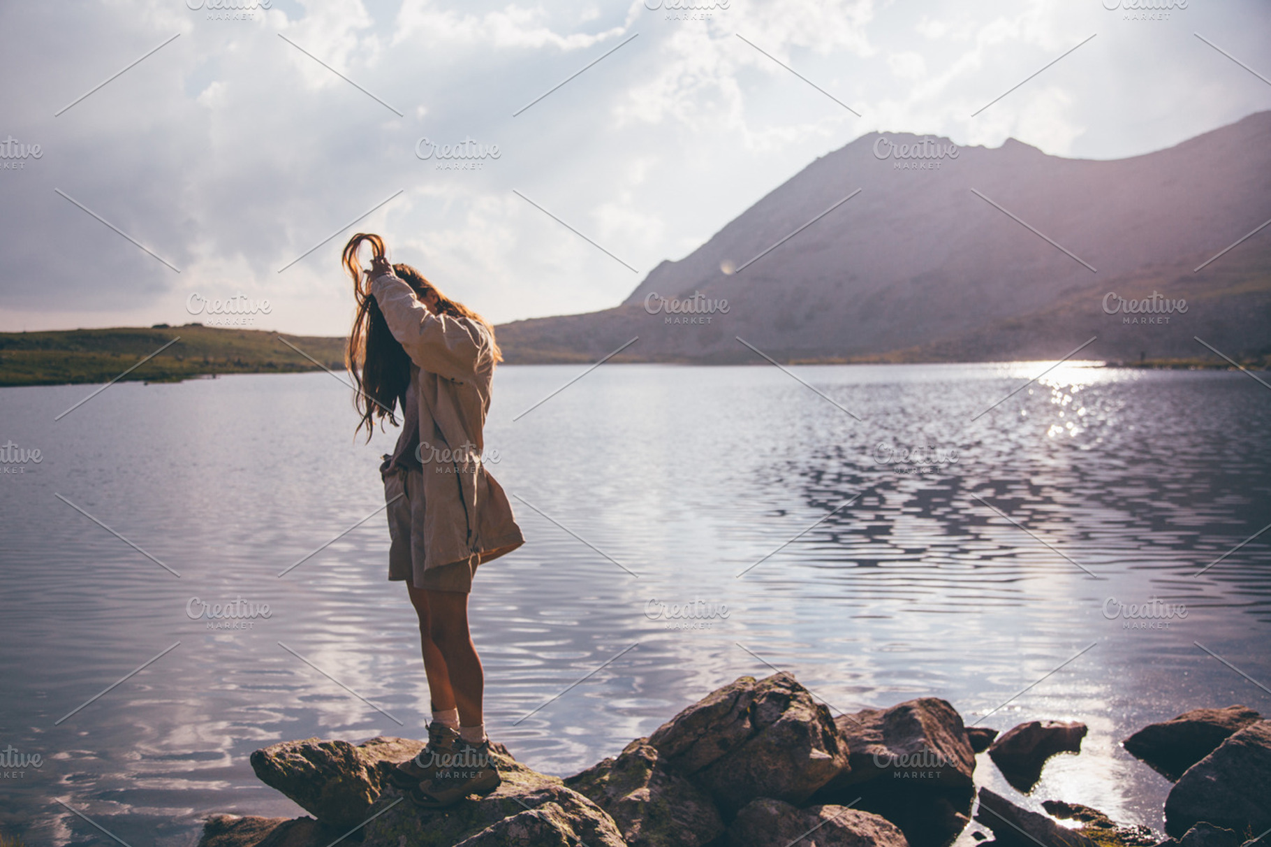 Young woman at a mountain lake, a Person Photo by Mukuko Studio
