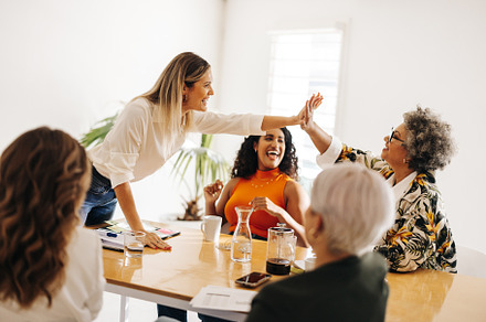 Business colleagues high fiving each other in a boardroom, a Person Photo by Jacob Lund