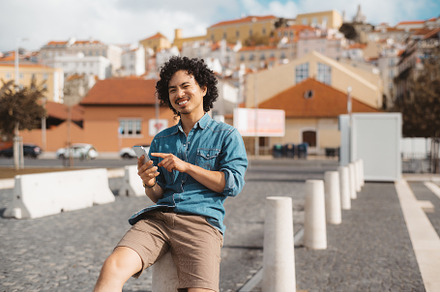 Smiling man using smartphone outside, a Person Photo by SkyNext
