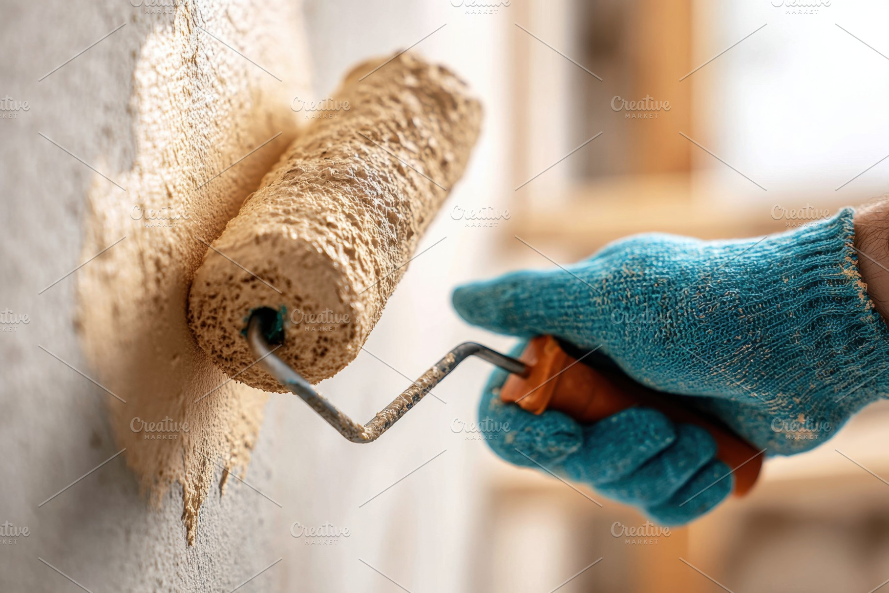 Hand applying paint with roller on wall in a room during daylight hours, an Arts & Entertainment Photo by AlyaAnd