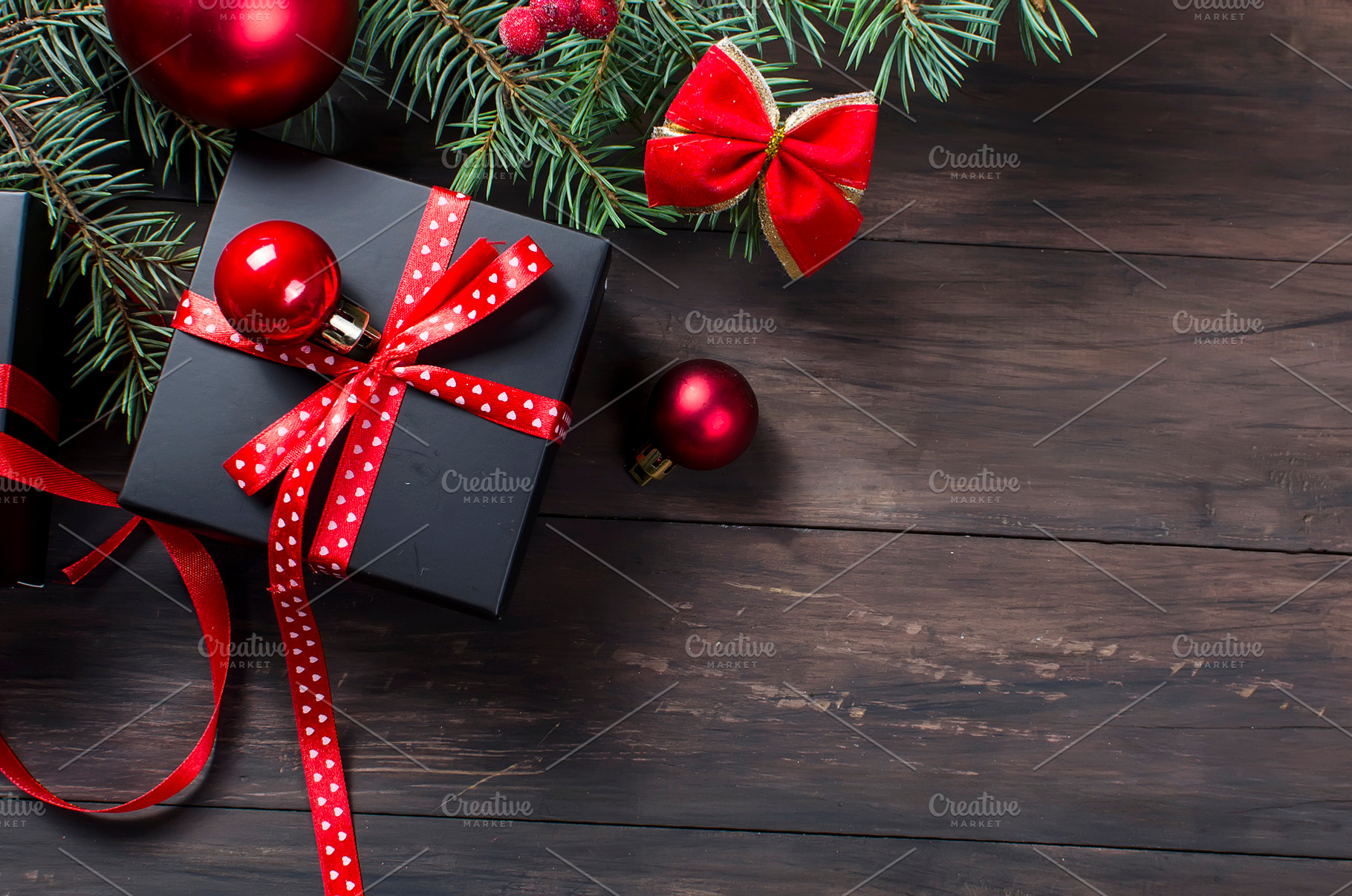 Black christmas gift box with red ribbon and fir branches, a Holiday Photo by vimart