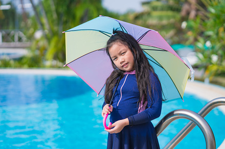 little girl smiling near in swimming pool and holding colourful, a Sports & Recreation Photo by Casanowe-studio