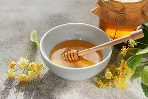 Linden honey bowl with wooden dipper and flowers, a Food & Drink Photo by Olena Rudo