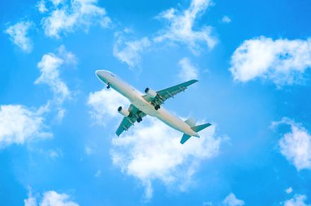 A plane flying in the blue sky stock photo containing airplane and plane, a Transportation Photo by Vapi