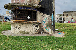 An abandoned police booth stands alone in an overgrown grassy ar, an Architecture Photo by DanFLCreativo