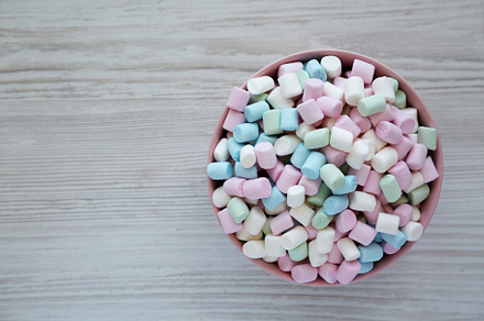 Rainbow Fruity Mini Marshmallows in a Pink Bowl on a white woode, a Food & Drink Photo by LiudmylaChuhunova